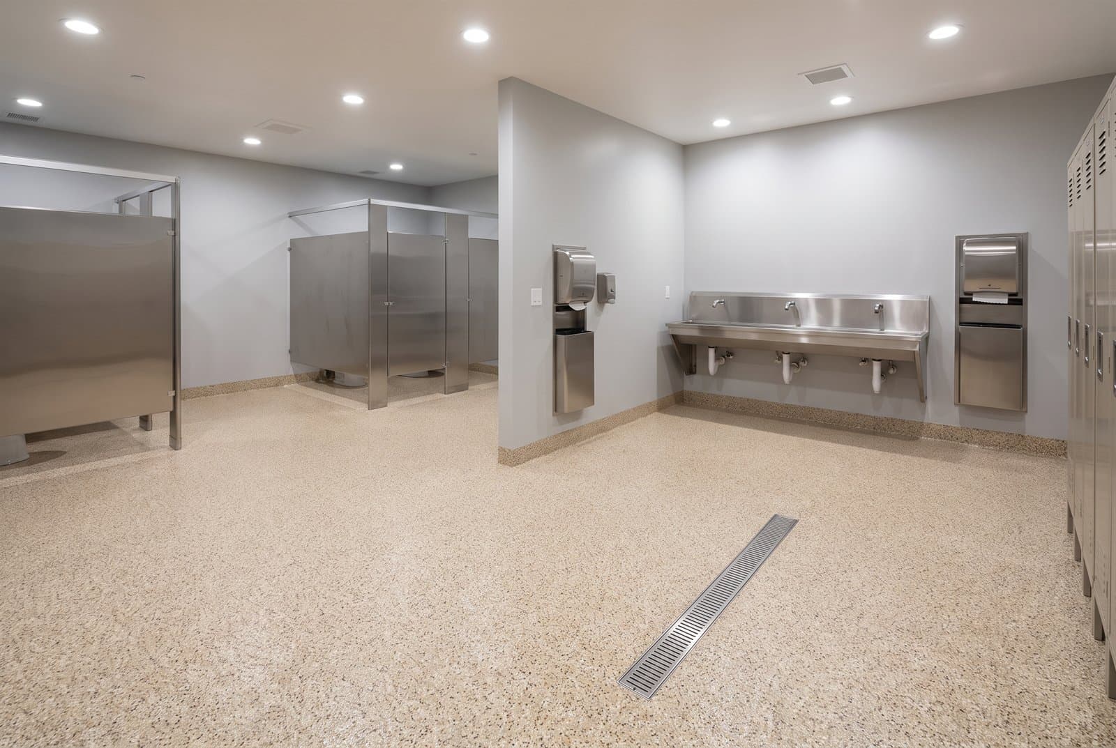 Tan quartz broadcast epoxy floor in a commercial locker area